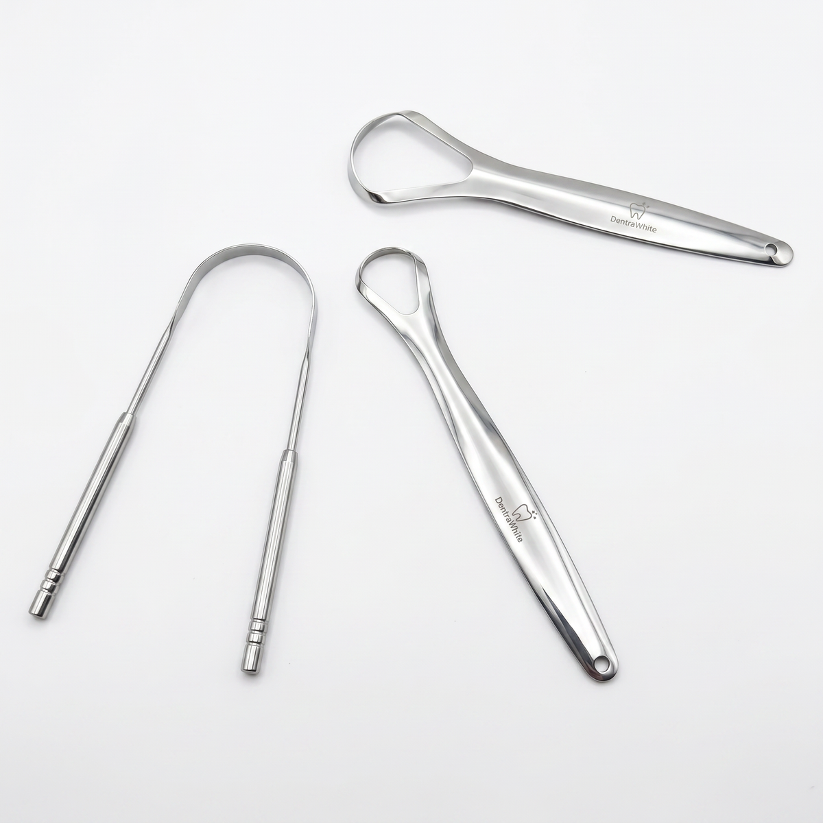 DentraWhite tongue scraper set with three stainless steel tools on a white background