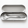 DentraWhite stainless steel tongue scraper tools stored inside an open silver travel tin